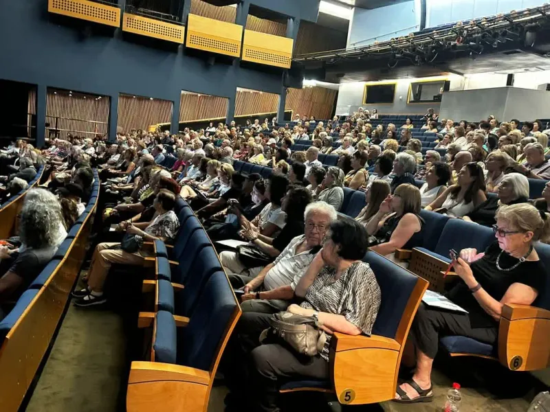 תמונת קהל יושבים באולם בזמן הרצאה של נתנאל לומר